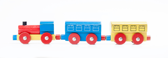 Wooden toy train with one carriage on wooden table with white background and copy
