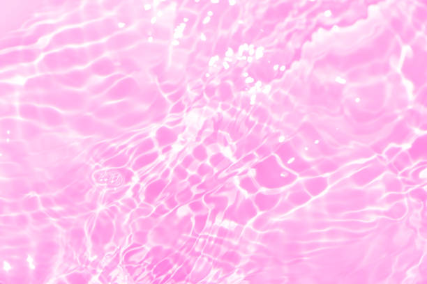 istock Pink water splashes on the surface ripple blur. Defocus blurred transparent pink colored clear calm water surface texture with splash and bubble. Water waves with shining pattern texture background 1918445900