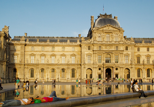 Paris, France, Europe - June 9, 2014 - “The Golden Louvre”: Blue Sky Summer Sunset Cityscape, Napoleon Courtyard and Louvre Palace Sully Wing (“Clock Pavilion”), Seine Neighborhood, UNESCO World Heritage Site, City Center, Monday 9:13 PM
