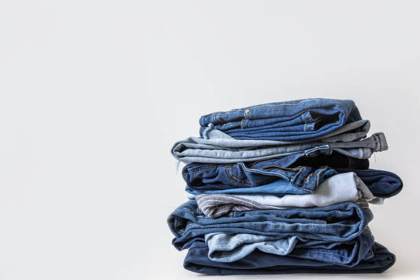 istock Stack of various shades of blue jeans on white background 1918571410