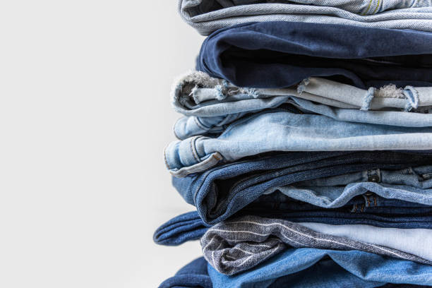 istock Stack of various shades of blue jeans on white background 1918573094