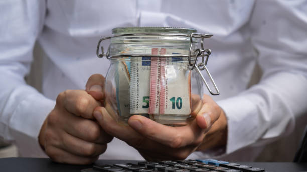 istock Euro Banknote Saving Money In Glass Jar. Unrecognizable man Moderate Consumption on calculator And Economy Collecting Money Tips Business Finance 1918578094
