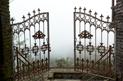 A metal gate opens up into the clouds at the Pura Pasar Agung Sebudi temple on the mountain after an ash eruption at Mount Agung on the popular tourist island of Bali.