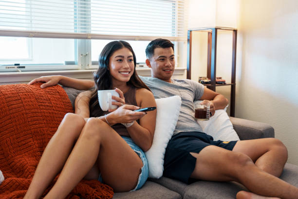 istock Loving couple drinking coffee and watching TV 1918696682
