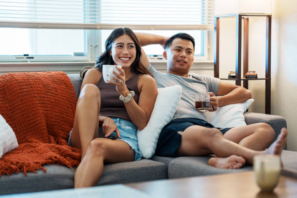 Loving couple drinking coffee and watching TV