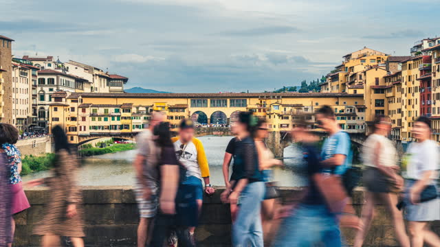 Time lapse of Crowd Diversity People Tourism walking and sightseeing in Ponte Vecchio bridge picturesque medieval arched river bridge area which have various jewelry souvenir shop, Florence, Tuscany, Italy