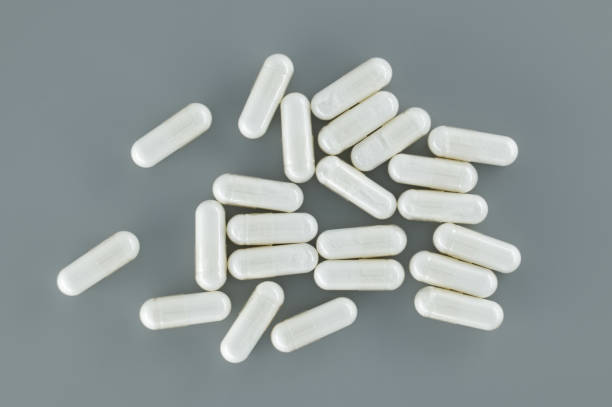 istock White capsules pills scattered on gray background 1918711869