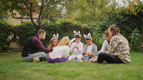 A group of children and parents are gathering at a family garden for Easter event.