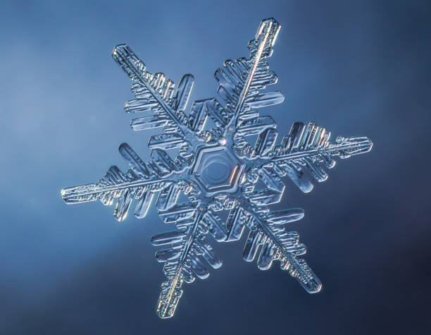 istock Snowflake on smooth gradient background. Macro photo of real snow crystal on glass surface. This is small snowflake with unusual pattern. 1918728628