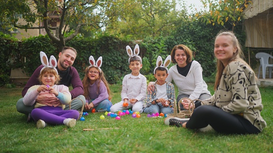 A portrait of a group of children and parents gathering at a family garden for Easter event.