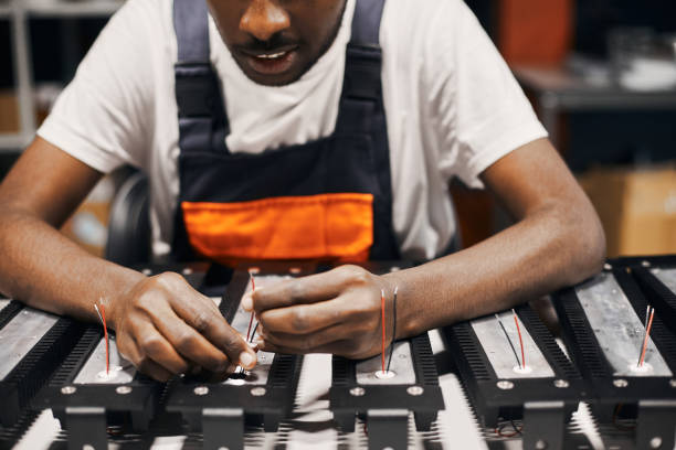 istock Factory worker connecting wires at circuit 1918760307