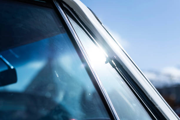 Shiny spotlight reflection on a chrome window frame in an old retro vintage car