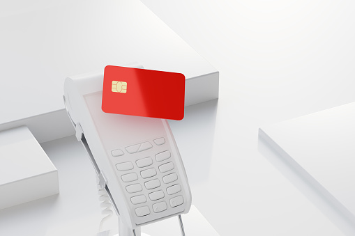 Red blank plastic banking card over the payment terminal (card reader), template for card design
