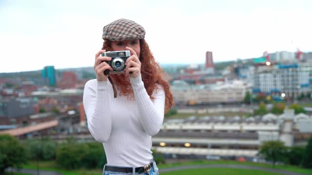 young happy woman with red curly hair looking into the camera
