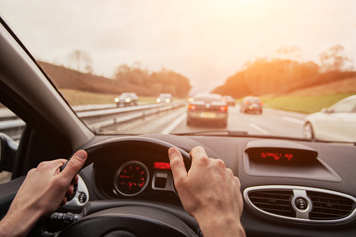 driving, travel by car, hands of car driver on steering wheel,  driving on highway road