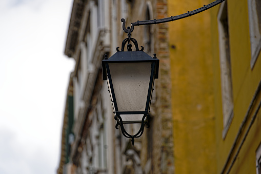 Old town of City of Venice with close-up of lantern on a blue cloudy summer day. Photo taken August 6th, 2023, Venice, Italy.