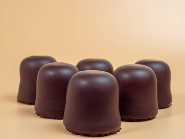 istock Marshmallows in chocolate glaze on an orange background. 1918946188