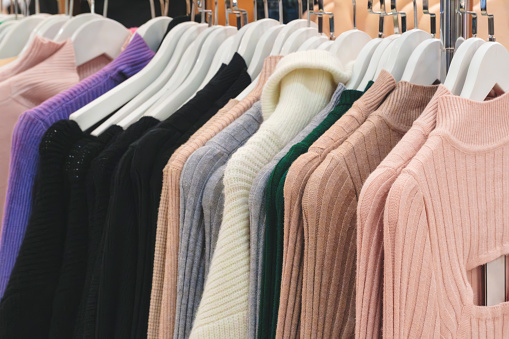 Women's sweaters on a hanger in a store. Classic women's fashion clothing.