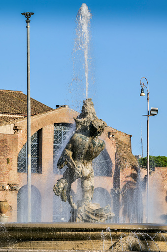 A view of the Fontana delle Naiadi (Fountain of the Naiads) in the center of Piazza della Repubblica (Republic Square), in the historic heart of Rome, with the archeological remains of the Terme di Diocleziano (Baths of Diocletian) in the background. The Fountain of the Naiads was built in 1870 during the pontificate of Pope Pius IX, a few days before the conquest of Rome by the troops of the Kingdom of Italy and the end of the temporal power of the papacy, by the artists Mario Rutelli e Alessandro Guerrieri. Piazza della Repubblica is located on the edge of the Rione Monti and the central Via Nazionale. In 1980 the historic center of Rome was declared a World Heritage Site by Unesco. Image in high definition quality.