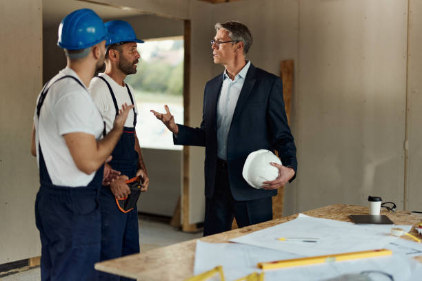 istock Displeased architect arguing with manual workers at construction site. 1918969309