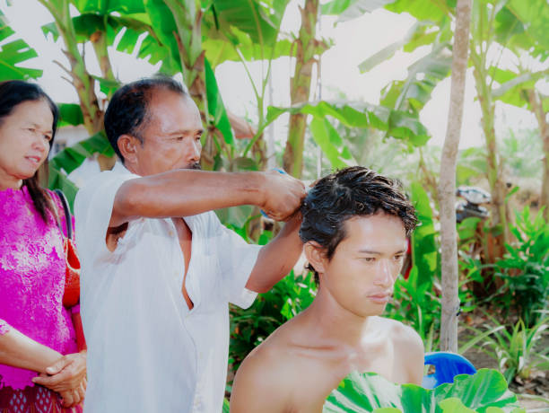 Nakhonsithammarat, Thailand- April. 08, 2016: Ordained, Father and Mother and people join together to shave the head of a young man who is about to be ordained, According to the principles of belief in Buddhism