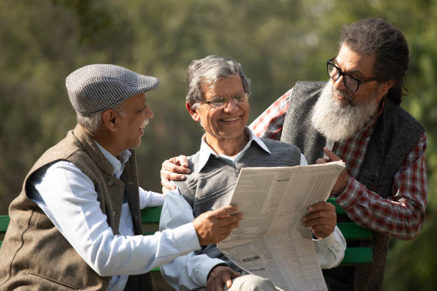istock Senior friends reading newspaper in park 1918990637