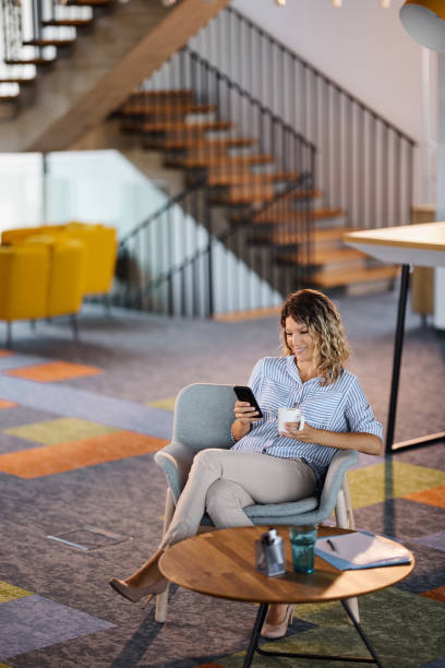 istock Happy businesswoman using cell phone on a break at casual office. 1918991015