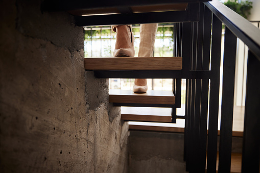 Close up of unrecognizable businesswoman walking up the stairs in high heels.