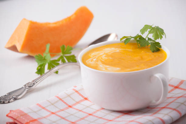 Pumpkin cream soup in a white plate stock photo