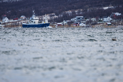 Fishing boat trawler sailing in a fjord
