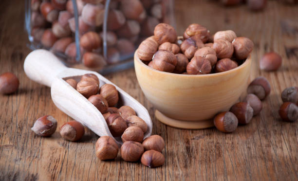 Hazelnuts in a  wooden spoon and wooden bowl stock photo