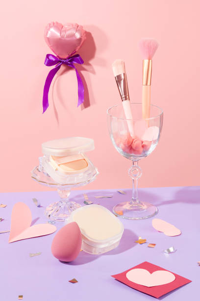 istock Cushion boxes, makeup sponges and makeup brushes are displayed with decorative paper on a pastel pink and purple background. Copy space with front view. 1919047665
