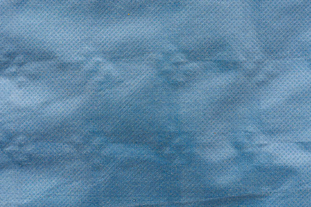 A macro shot of a pale blue fabric featuring an intricate pattern of tiny dots.