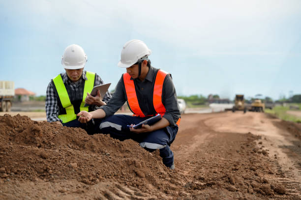 Highway engineers touch and inspect laterite soil for construction improvement base road work, Civil Engineer work in the inspector job in highway construction.