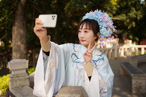 Woman wearing Chinese costume taking selfie