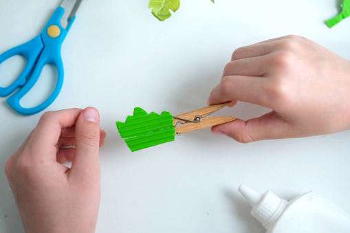 Children's craft made from paper and clothespins. step by step instructions from green paper. DIY concept. Step-by-step photo instructions. Step 11.
