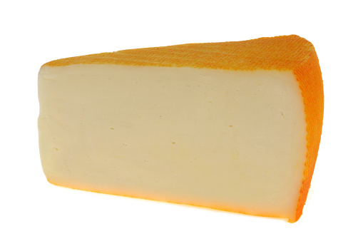 Piece of Saint-Paulin cheese close-up on white background