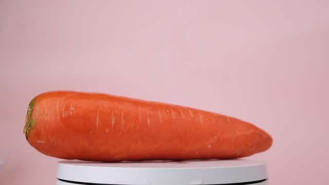 Carrot rotating on a pink background.