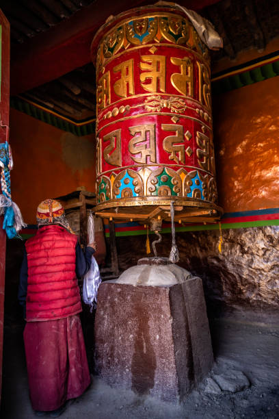 a young tibetan buddhist monk turning the prayer wheels, lo manthang, upper mustang, nepal - monk tibet buddhism china ストックフォトと画像