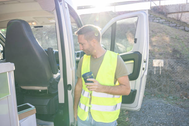 istock Delivery man on a break next to his tuck having coffee 1919203822
