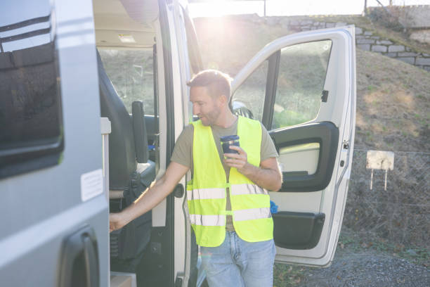 istock Delivery man on a break next to his tuck having coffee 1919203827
