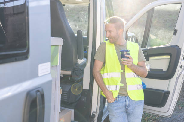 istock Delivery man on a break next to his tuck having coffee 1919203830