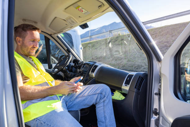 istock Delivery courier having a break in his truck using his mobile phone 1919205390