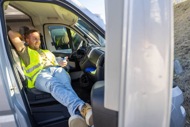 istock Delivery courier having a break in his truck using his mobile phone 1919205394