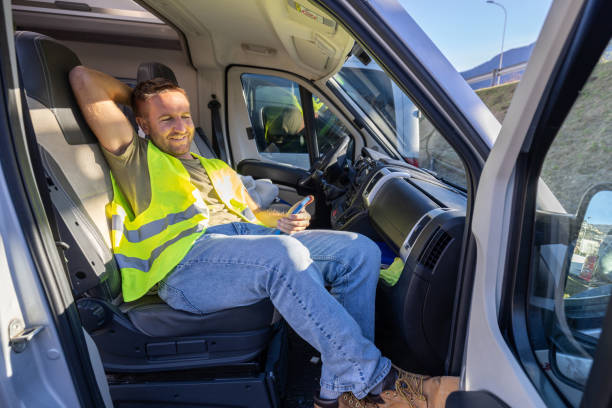 istock Delivery courier having a break in his truck using his mobile phone 1919211268