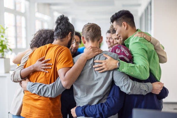 Business team standing in a circle together during a team building workshop