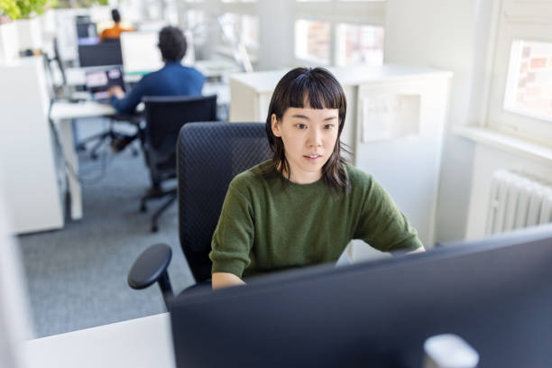 istock Young woman orking on desktop PC at startup office 1919240545