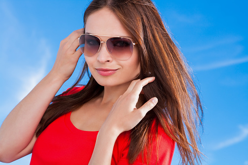 Ukrainian female wearing sunglasses against blue sky