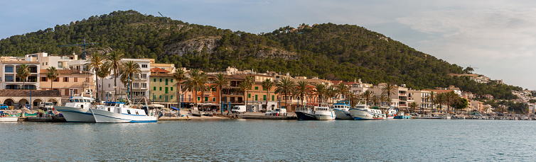 Panoramic view of the dock with fishery ships in Andratx in the island of Majorca, Spain with mountains in background. Mediterranean sea, touristic concept