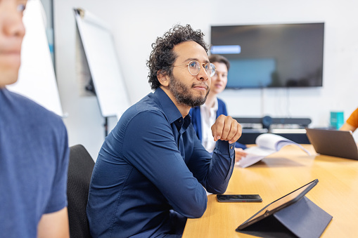 Businessman sitting at startup office conference table and listening to the conversation. Business team having meeting at office board room.